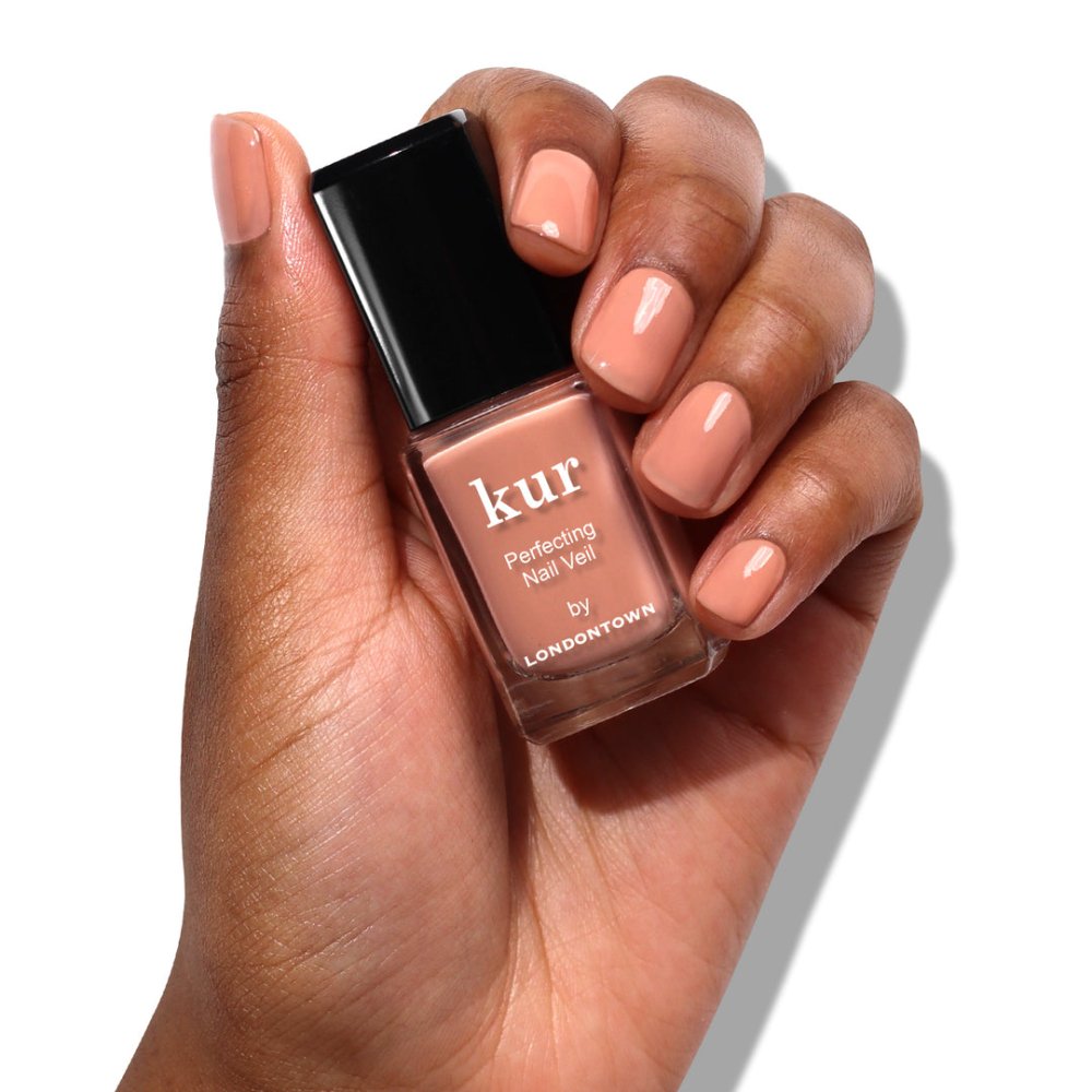 Ruka s lahvičkou Nail Veil No.5 a nalakovanými nehty