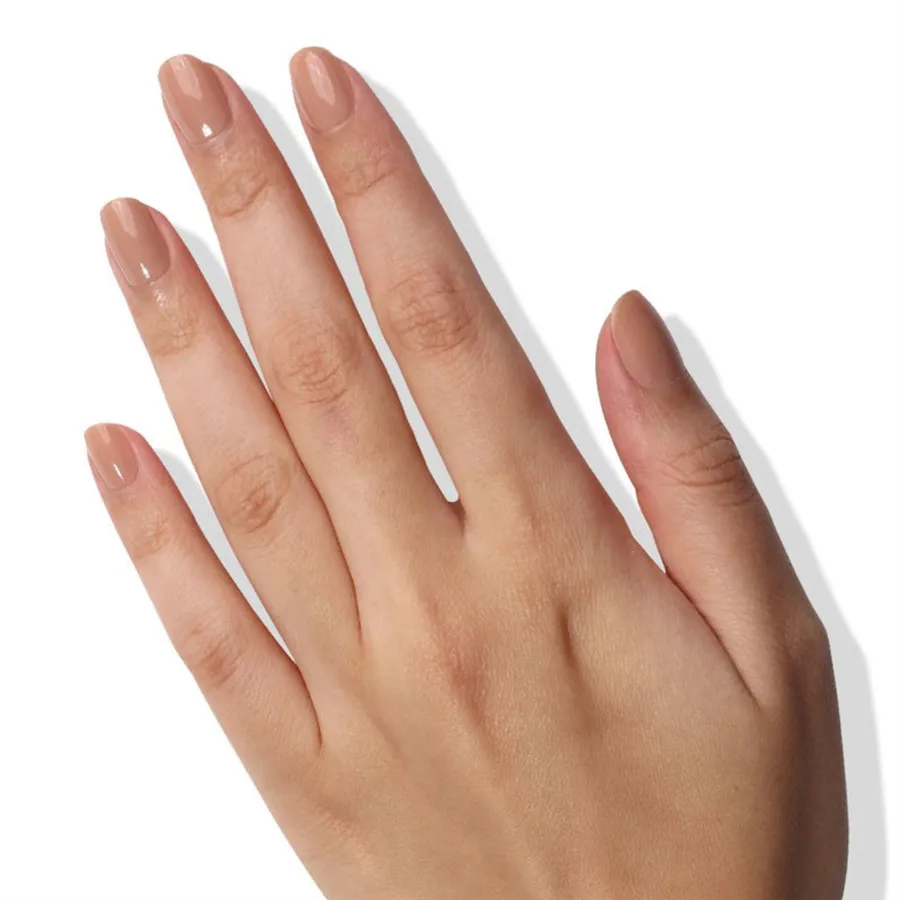 Dłoń z buteleczką Nail Veil No.6 i pomalowanymi paznokciami