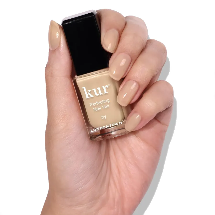 Dłoń z buteleczką Nail Veil No.2 i pomalowanymi paznokciami